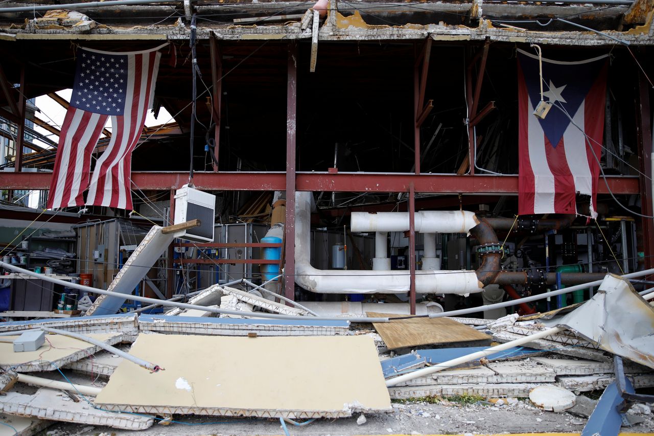 The American and Puerto Rican flags hang on a church damaged by Hurricane Maria.