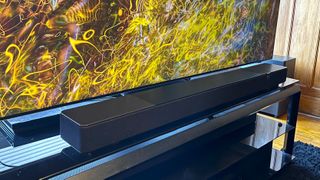 Klipsch Flexus Core 200 soundbar on TV stand with colorful abstract image on screen