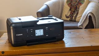 Lifestyle photo of Canon PIXMA TR7520 inkjet 4-in-1 printer in a home setting on a wooden table