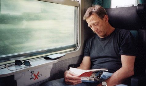 Larry Sultan pictured reading a book on the train