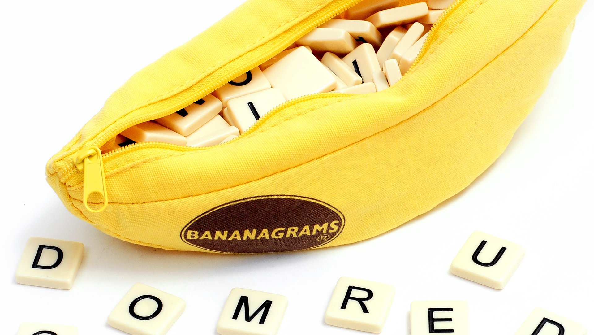 melhores jogos de tabuleiro para dois jogadores – bolsa de bananas em forma de banana, com algumas peças espalhadas na frente dela