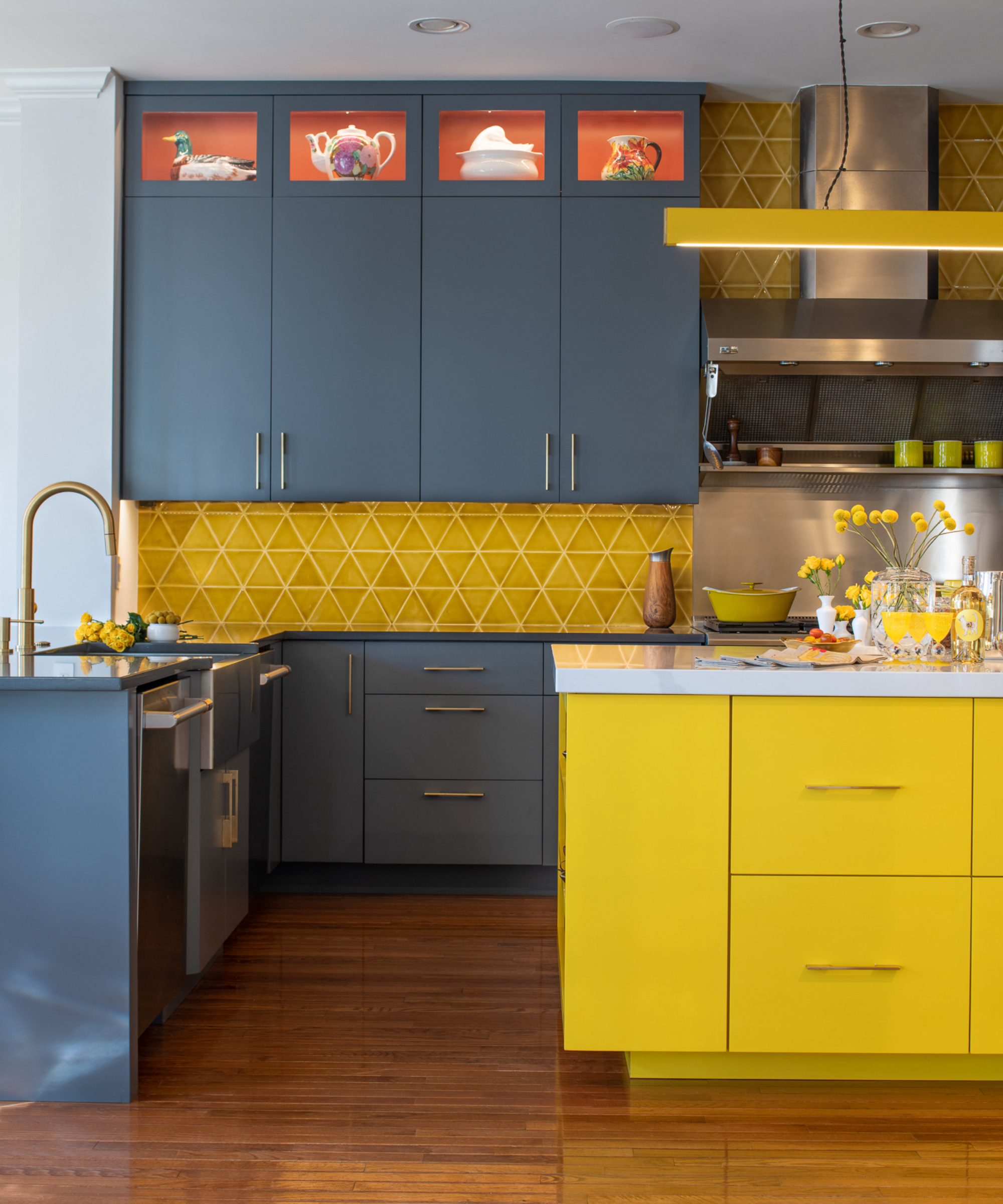 charcoal black kitchen with yelllow cabinetry and backsplash, chery wood floor, yellow accessories