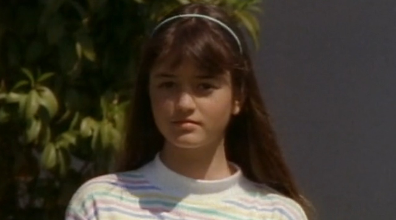 Winnie Cooper (Danica McKellar) stands in her yard on The Wonder Years.