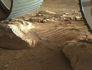 NASA's Perseverance Mars rover perched atop nearby rocks to shake loose the last two stuck pebbles by twisting with one foot.