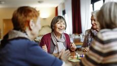 A group of older women in a retirement community play a board game.