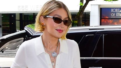 Gigi Hadid leaving a car wearing a white sweater and a slip skirt