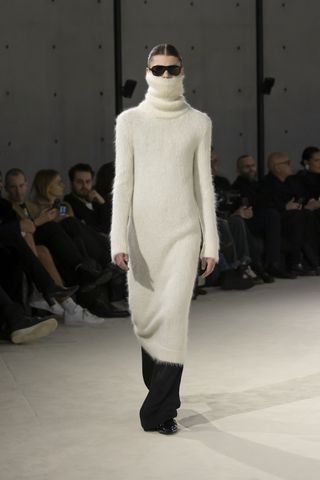 Model on Saint Laurent runway in cream jumper that covers the face