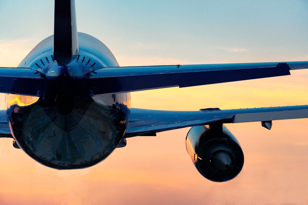 Low Angle View Of Airplane Flying Against Sky During Sunset