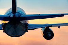 Low Angle View Of Airplane Flying Against Sky During Sunset