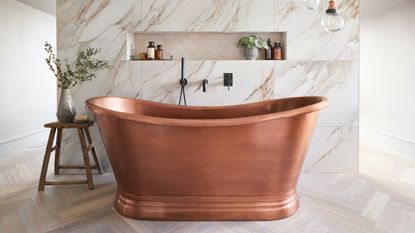 copper boat bath in marble bathroom