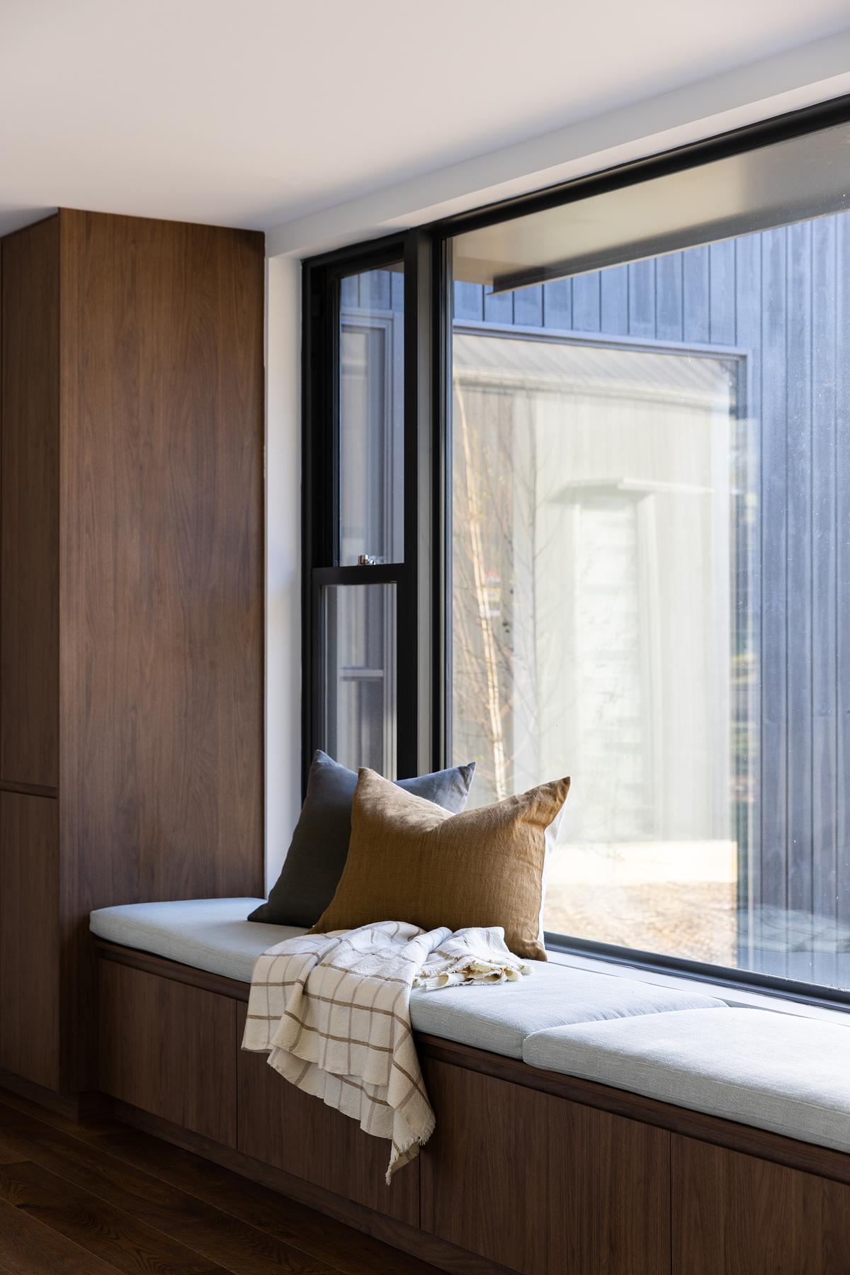 built in dark wood storage with a built-in bench seat