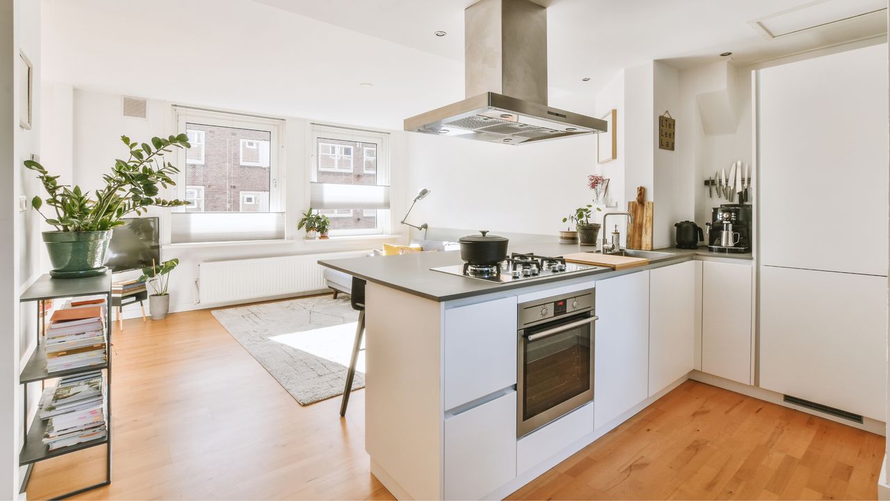 A bright white kitchen with island counter that isn&#039;t overwhelmed with small kitchen clutter