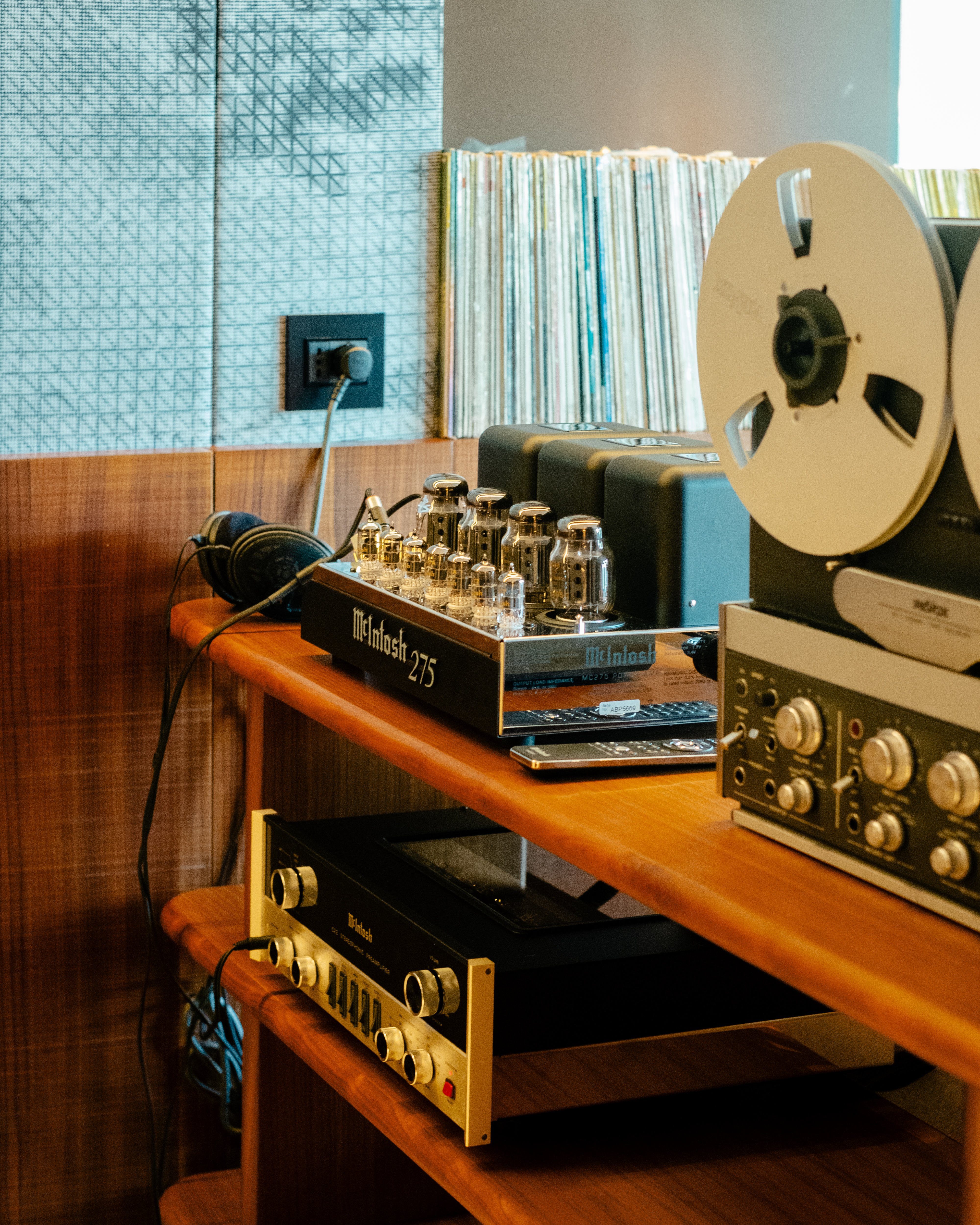A high-fidelity suite fitted with retro-inspired amplifiers, speakers, a turntable, and a sprawling record collection features a mid-century-cool vibe through wood-clad surfaces and sculptural designs.