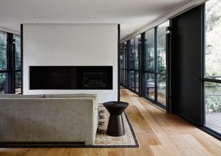 bridging boyd by jolson, a modernist house refreshed with white walls, black framing and details and a overgrown leafy garden seen through large glazing