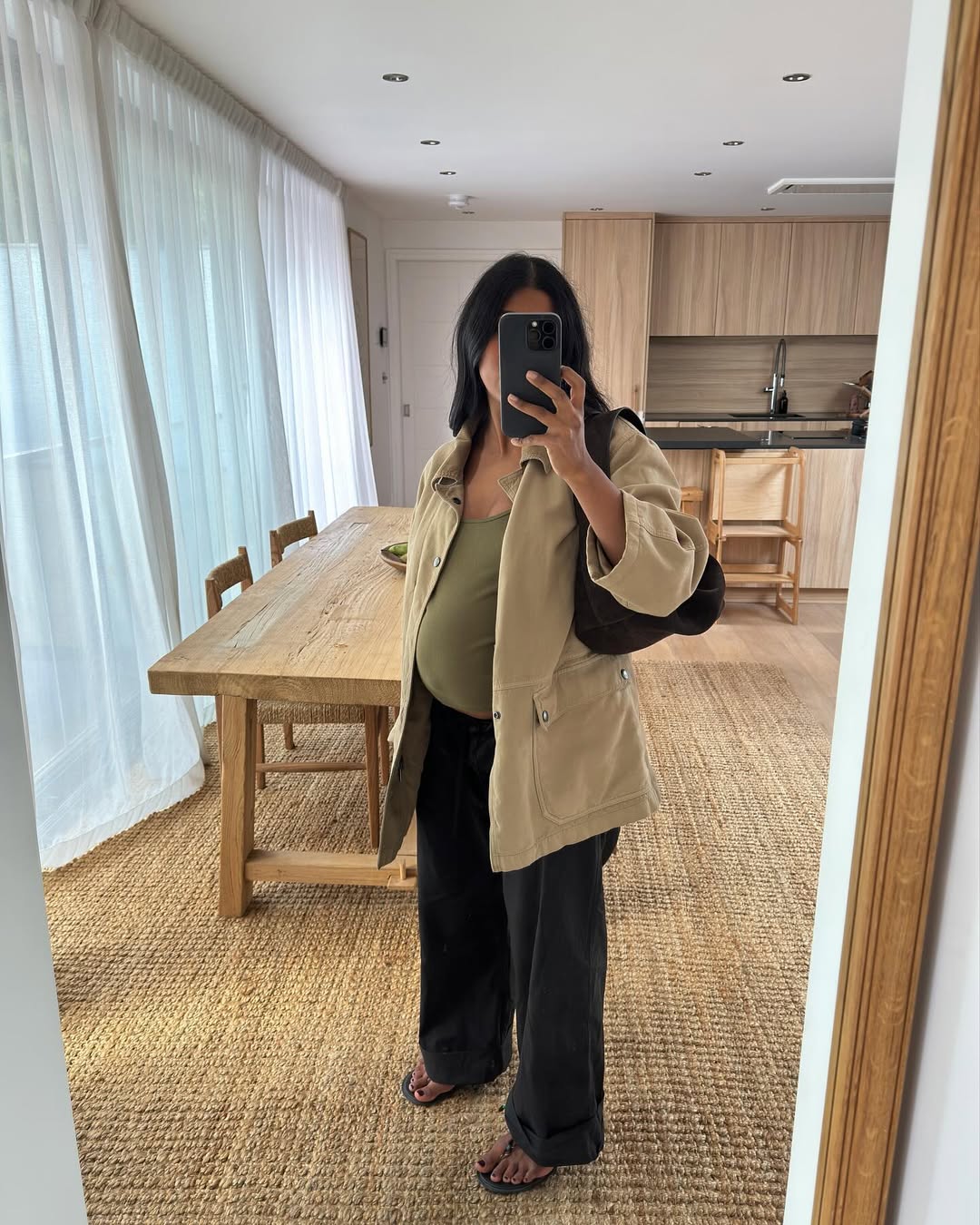 monikh wears cream barn jacket, jeans and sandals