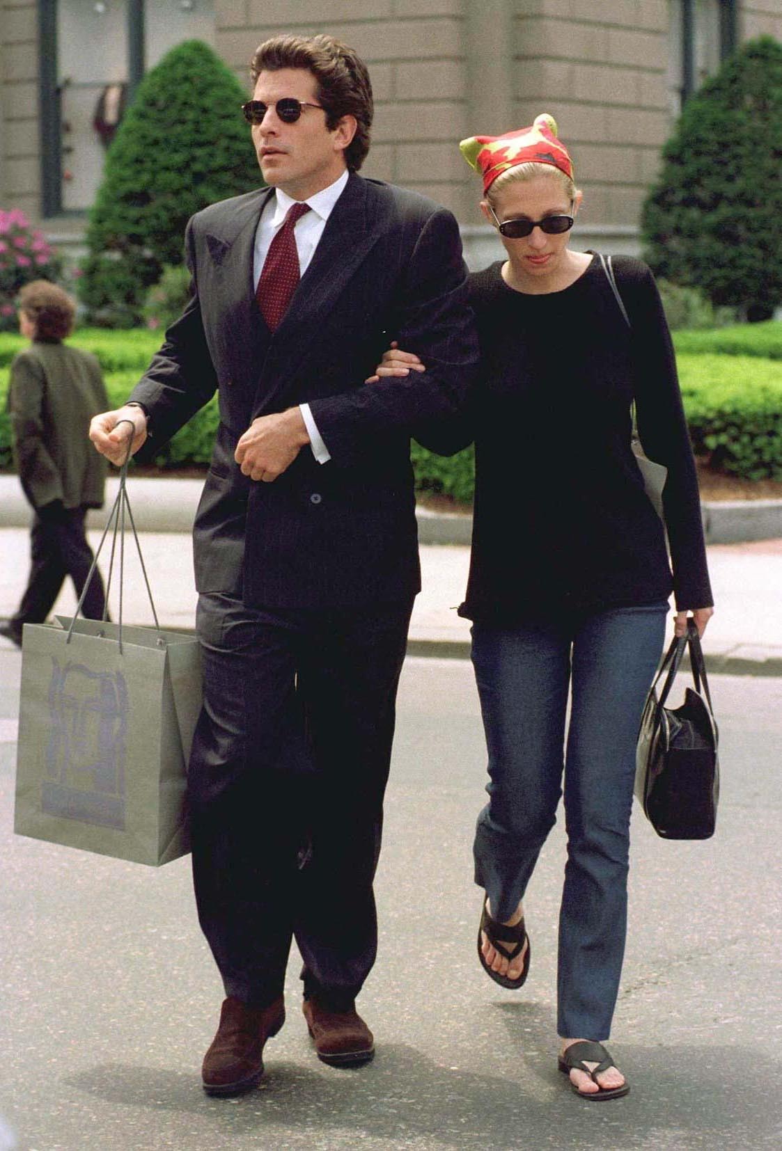 Carolyn Bessette Kennedy wearing a colorful headscarf with a black top and jeans.