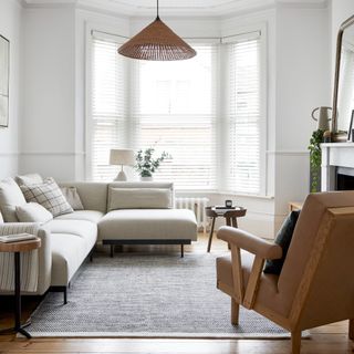 A living room with a high ceiling, a cream corner sofa and an open floor plan