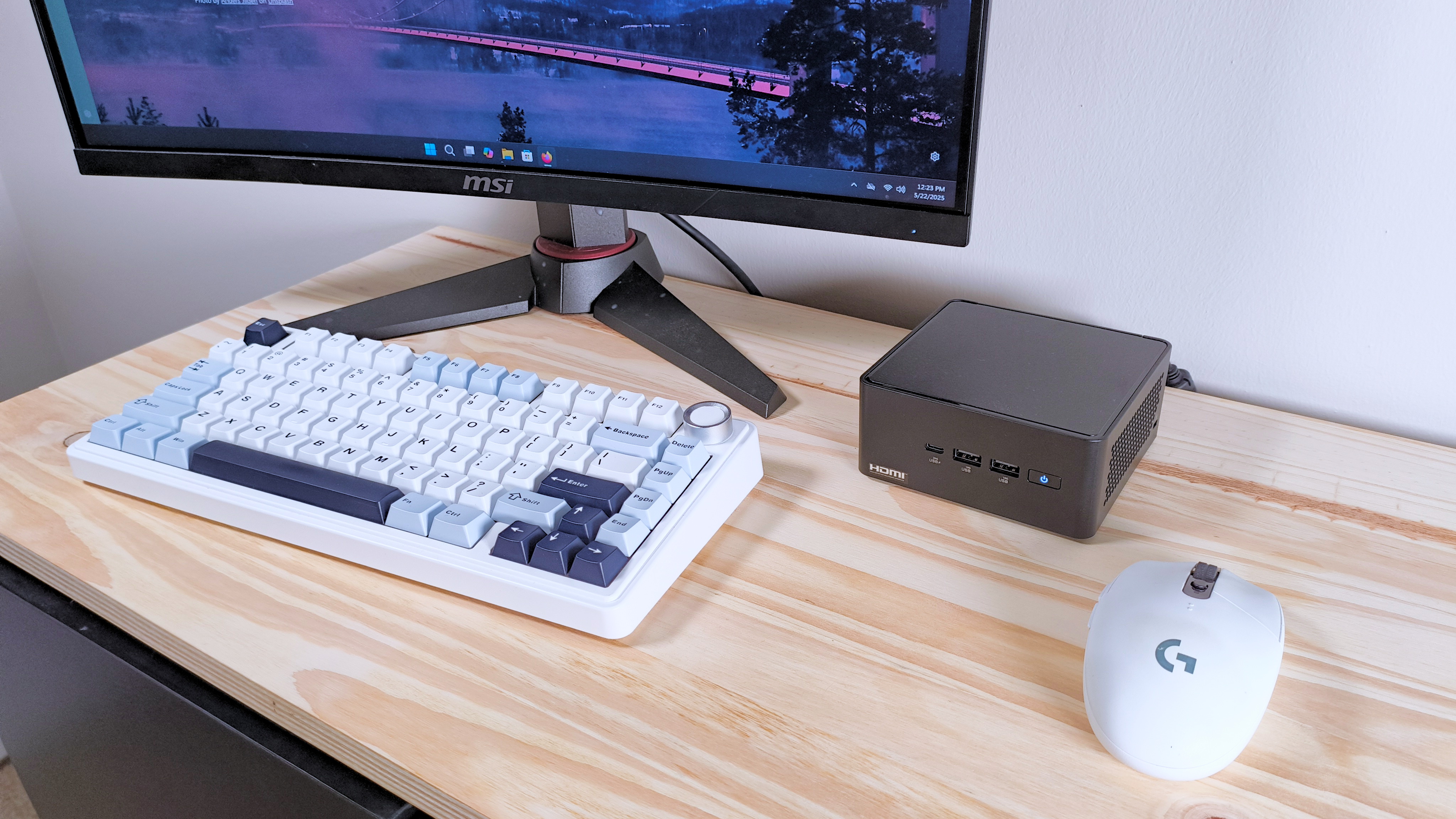 The Asus NUC 14 Pro on a table next to a mouse, keyboard, and monitor, seen from above