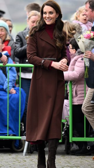 Kate Middleton in a brown tailored coat and boots