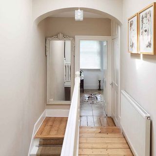 white walled landing area with wooden floor