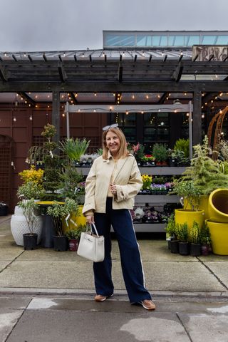 A Nordstrom stylist wearing track pants and neutral sneakers.