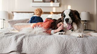 A St Bernard dog shares a bed with two young children