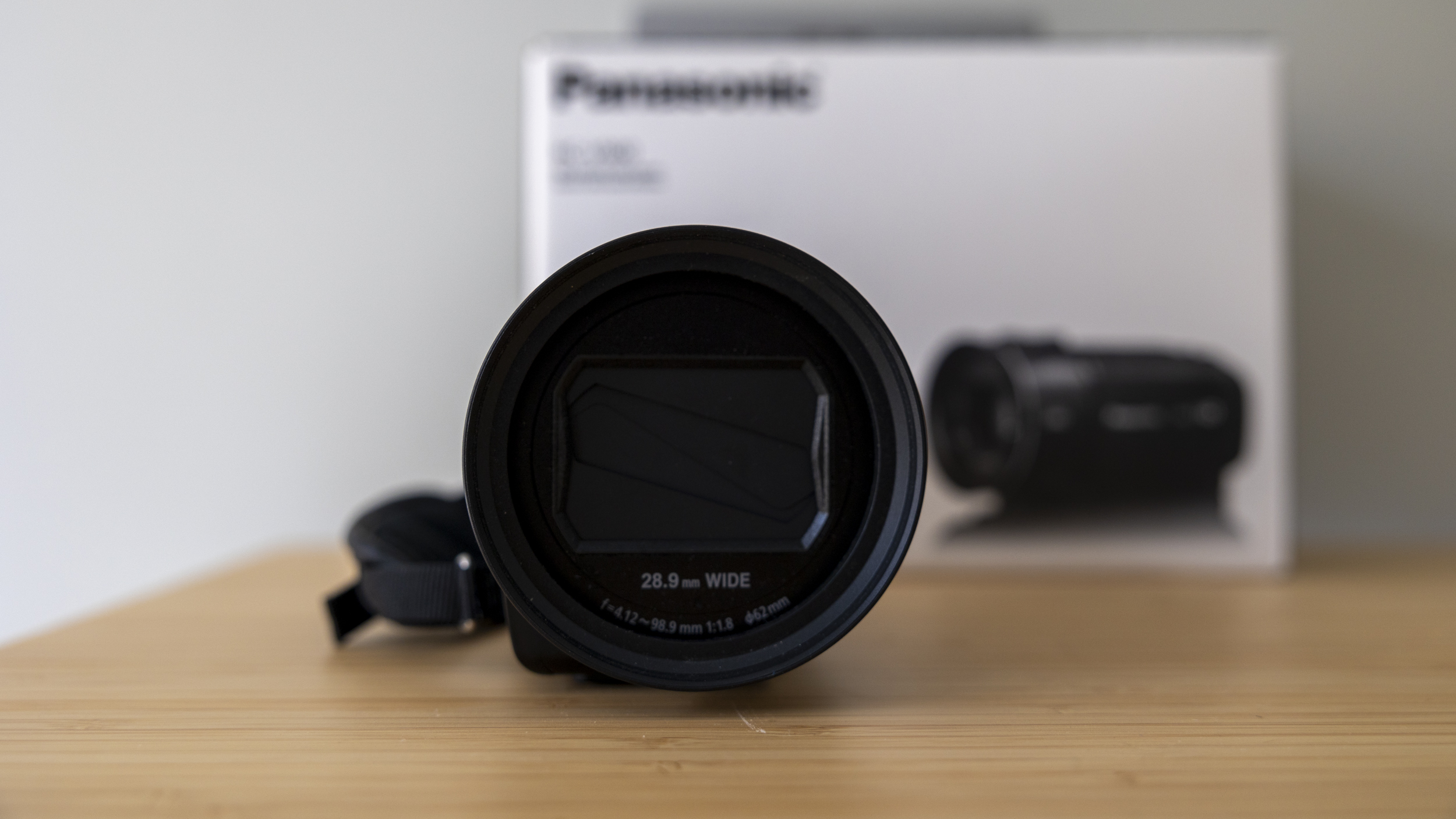 A front view of the Panasonic HC-V900 on a light wood desk