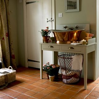 utility room with washbasin and terracotta tile flooring