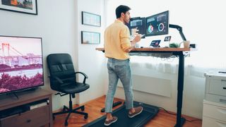 Man walking on a treadmill while working