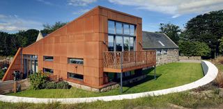 A striking Cor-ten steel-clad extension to a granite steading in Aberdeenshire offers open plan living to its owners