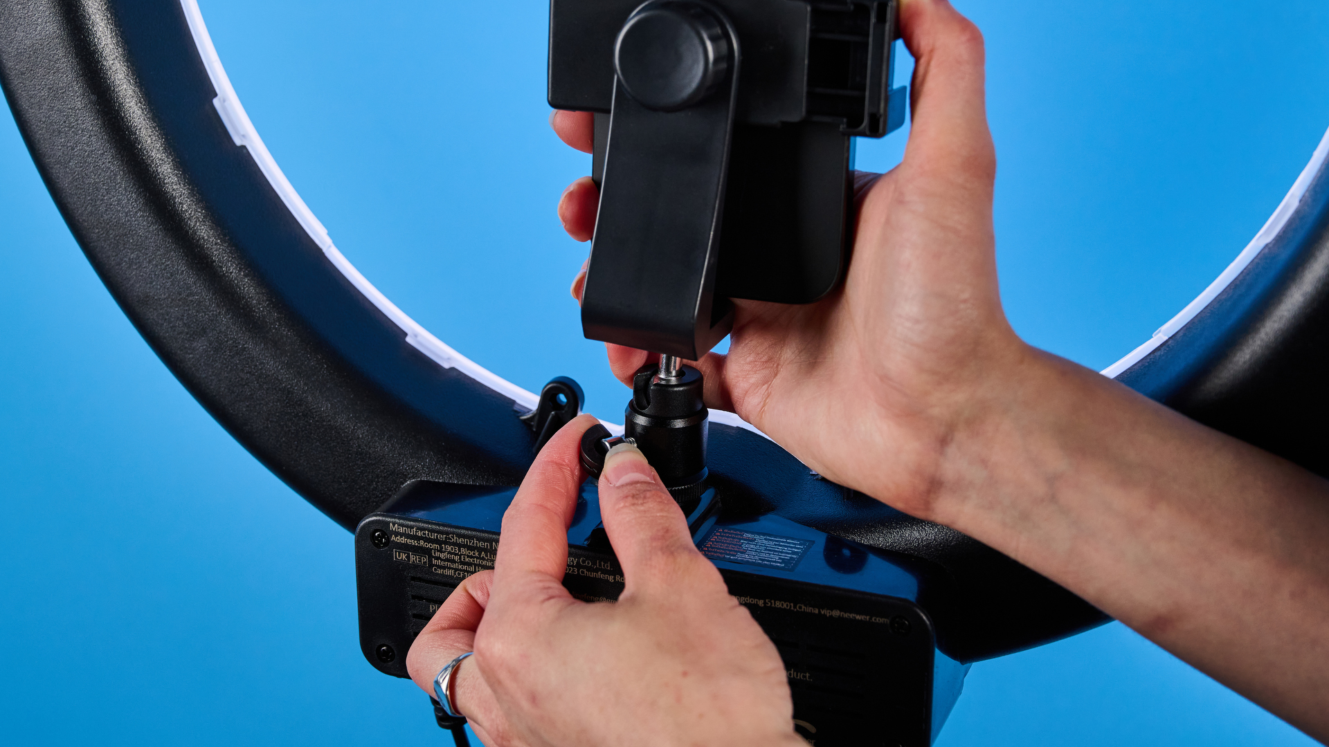 Neewer RL-18 ring light photographed in front of a blue background.