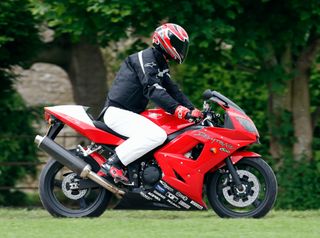 Prince William arrives, riding his Triumph Daytona 600 motorbike, to play in the Burberry Cup polo match at Cirencester Park Polo Club on June 17, 2005 in Cirencester