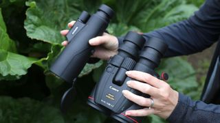 Someone holding a pair of binoculars and a monocular