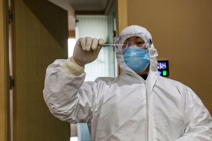 Health care provider checks thermometer in China