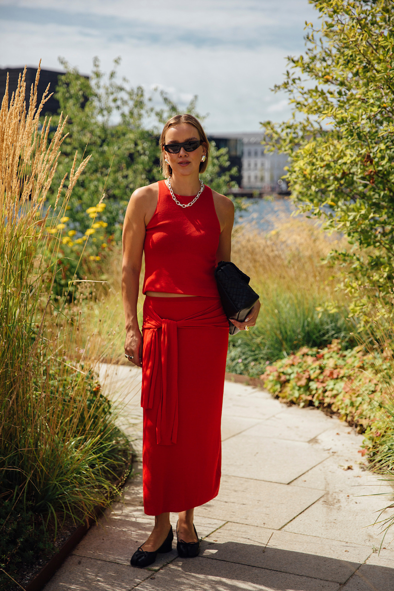 woman wearing a red tank, red skirt, and black flats in Copenhagen.