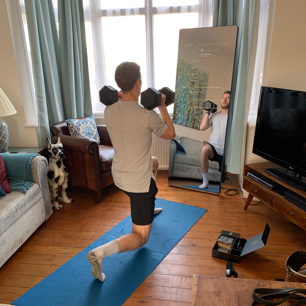 Reviewer exercising in front of Vaha X fitness mirror
