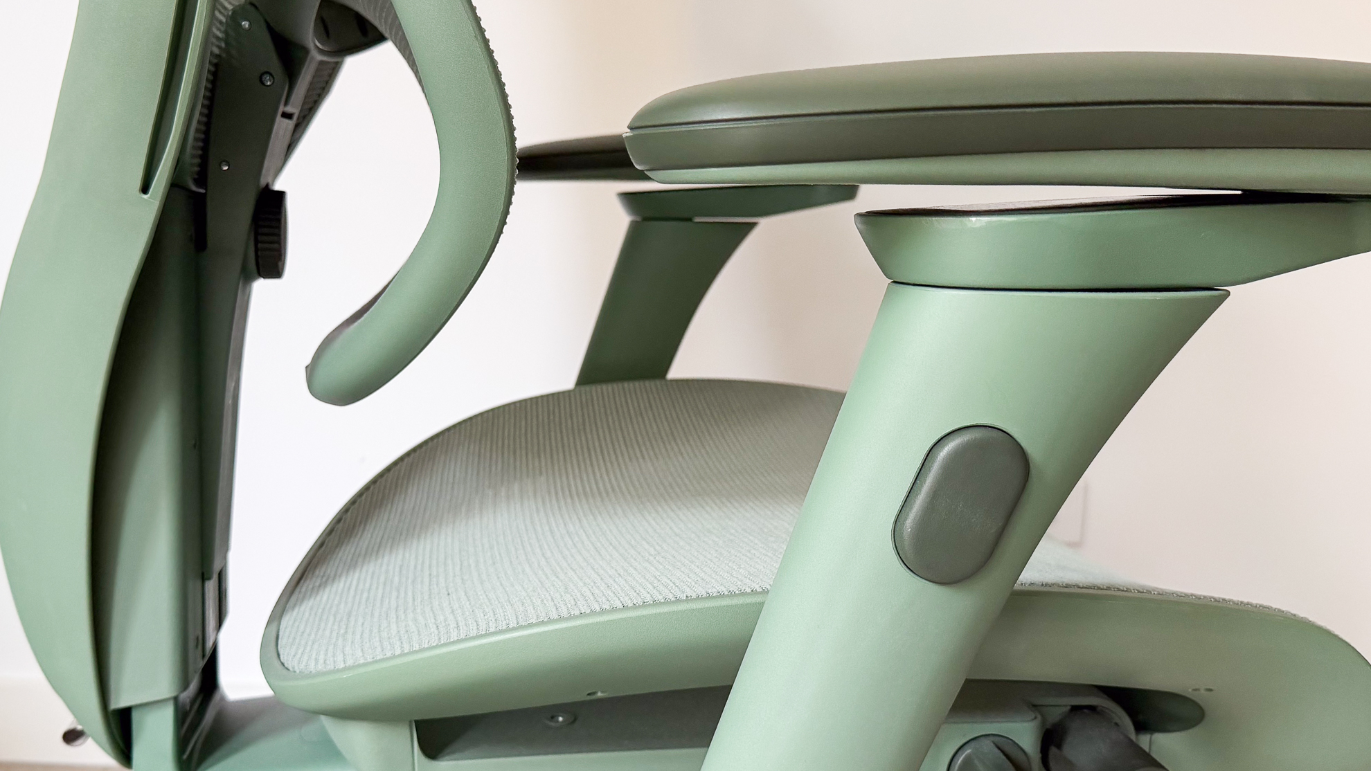 Height adjustment button on the side of an armrest on the ErgoTune Vesby office chair