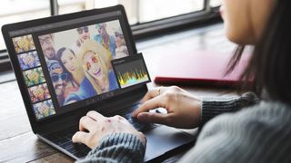 Woman working on laptop editing photos