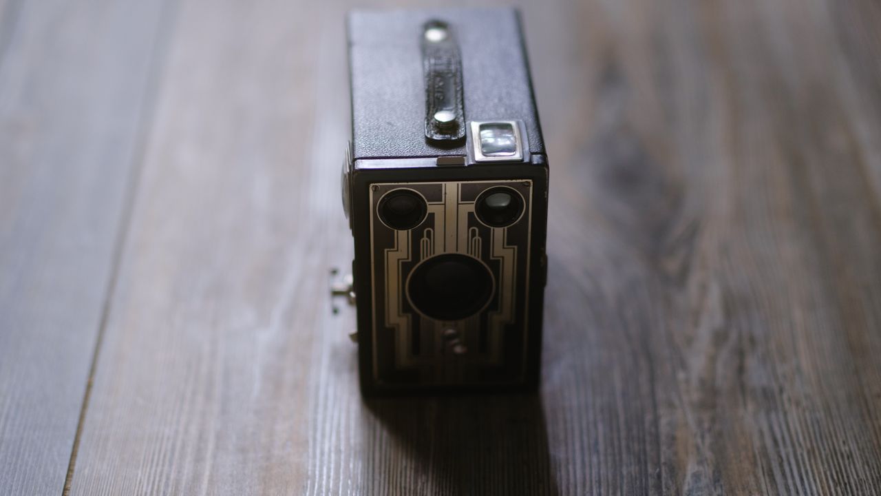 A photo of a vintage box camera taken under different lighting conditions