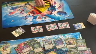 Altered: Trial by Frost cards on playmats, with a hand shuffling yellow cards