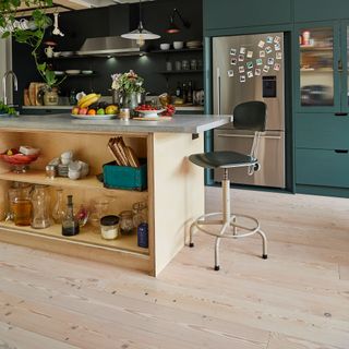 wooden flooring kitchen with countertop and teal coloured cabinets