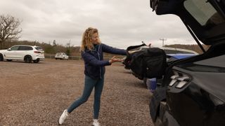PGA pro Katie Dawkins throwing a bag into a car boot
