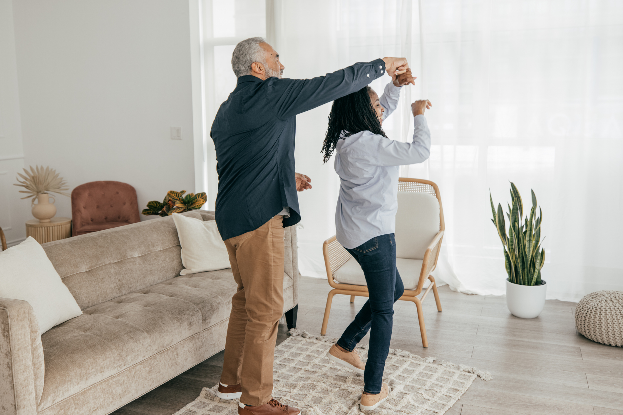 Couple dancing in their home. Equity release and downsizing are both options available to homeowners.