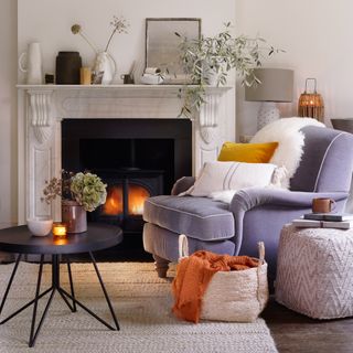 Neutral living room with cosy fireplace and grey armchair