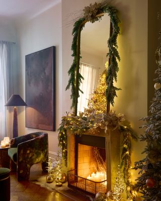 a fireplace decorated for Christmas with garlands and lights