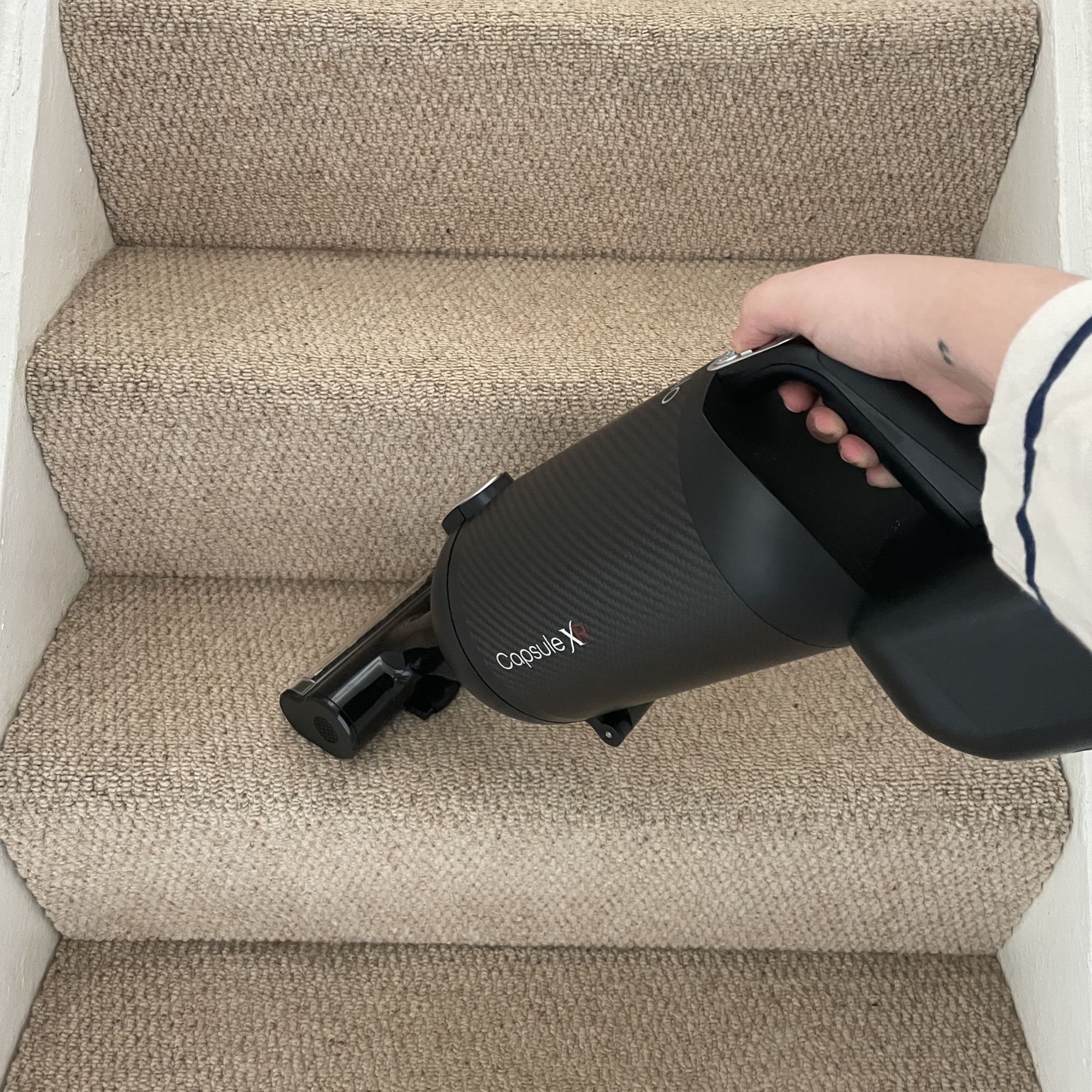 Using the Halo Capsule XR Cordless Vacuum Cleaner handheld to vacuum cream carpeted stairs