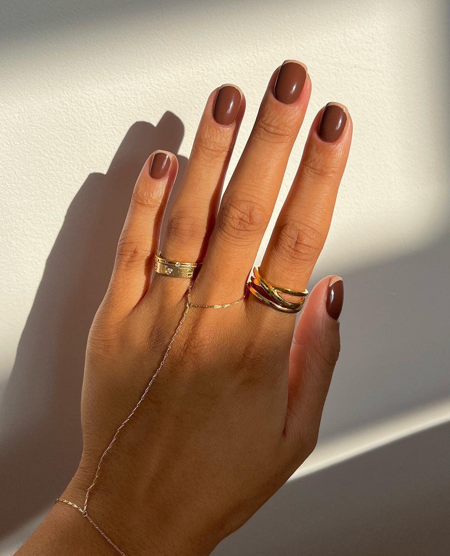 A chestnut brown, French tip design manicure