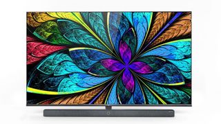 TCL X10 QLED on a TV stand and displaying vibrant colors in the shape of a flower