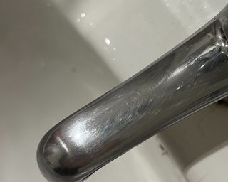 A chrome faucet over a white porcelain sink