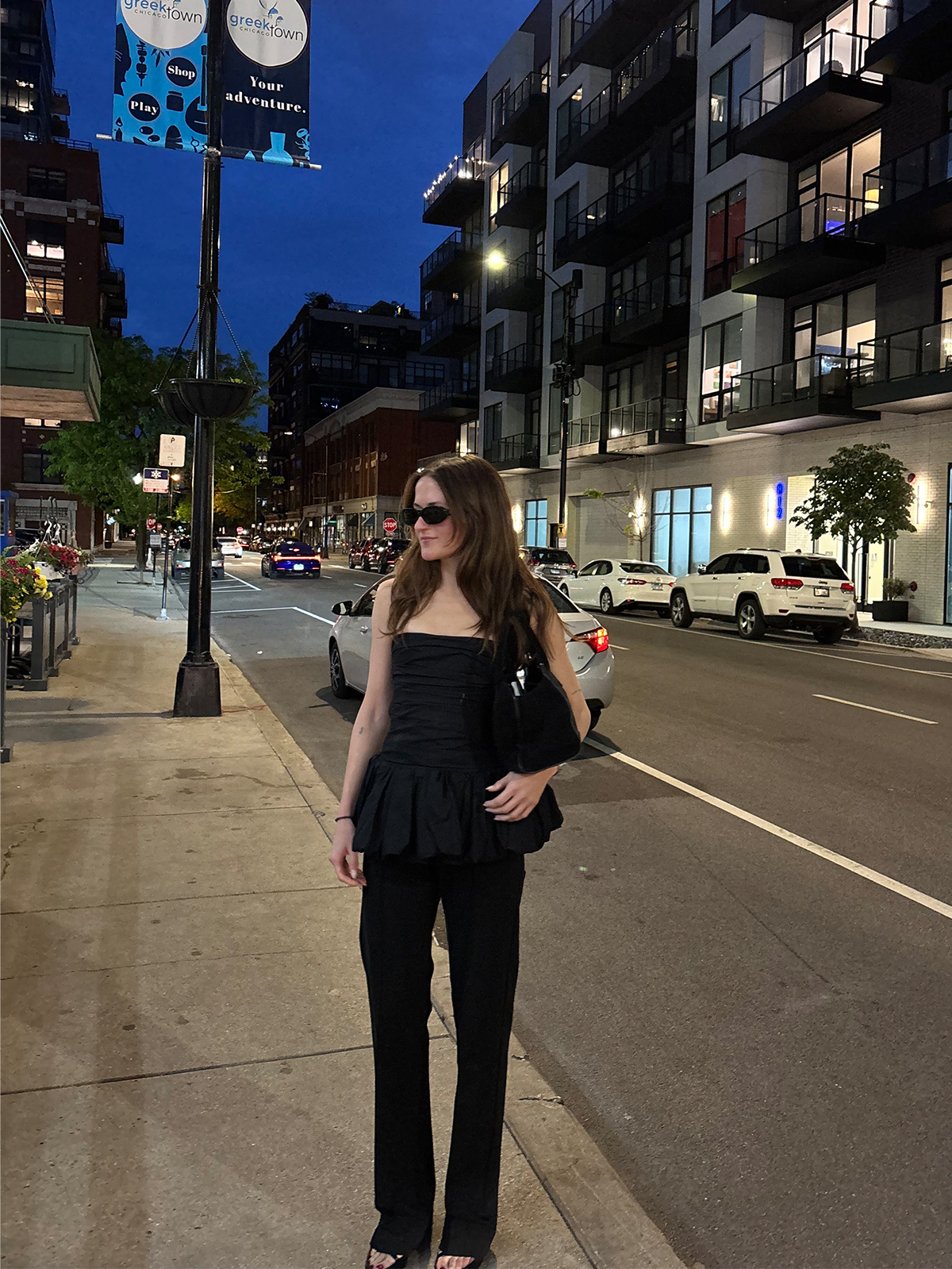 Eliza Huber in Chicago wearing a black peplum Khaite top with black Kallmeyer trousers.